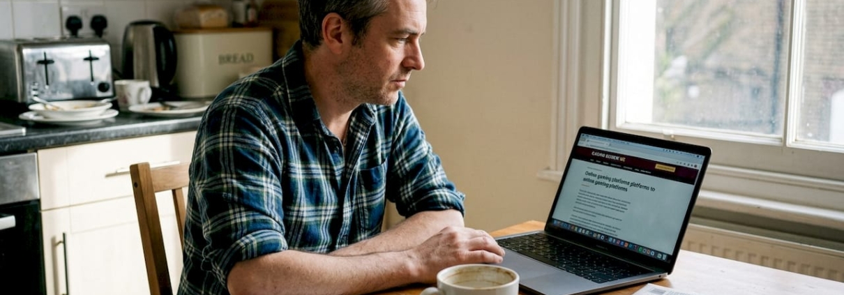 Man reading casino review at kitchen table