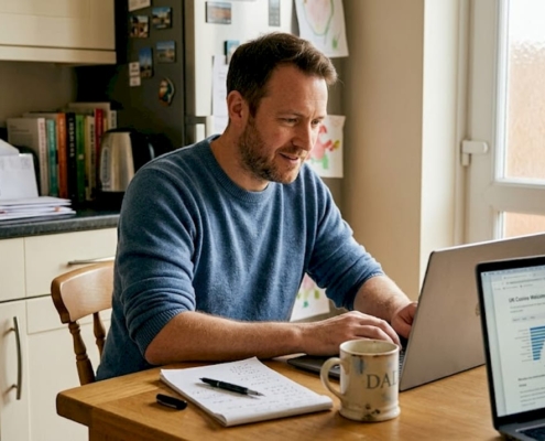 Man comparing casino offers on kitchen laptop