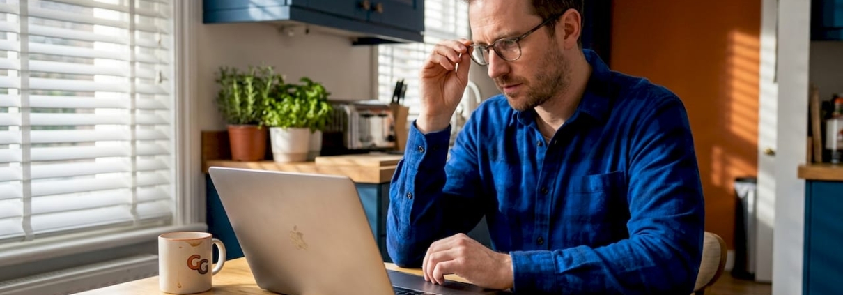 Man checking casino balance at kitchen table